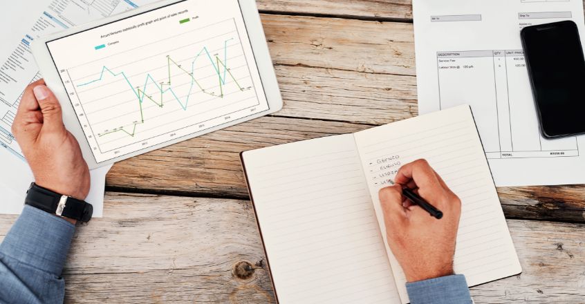 Persona analizando gráficos de consumo y tarifas eléctricas para reducir consumo de electricidad en el hogar