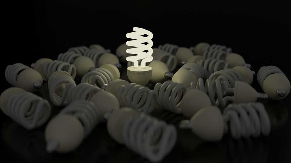 Bombilla fluorescente compacta (CFL) de bajo consumo, con tubo en espiral encendido sobre fondo oscuro