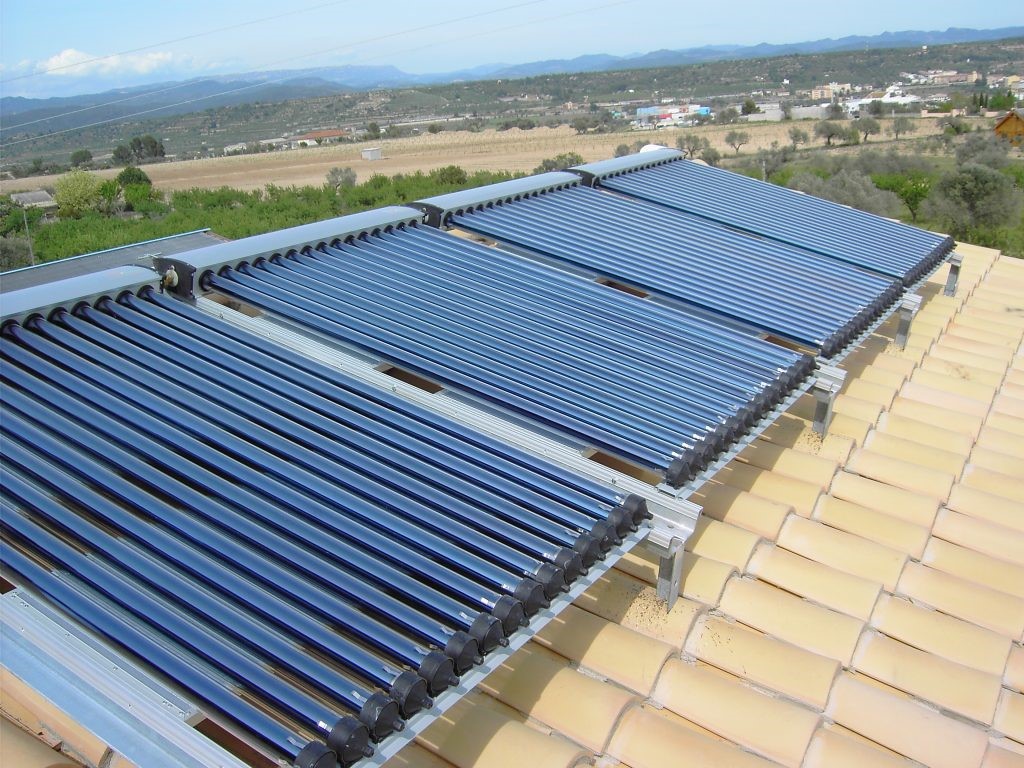 Paneles solares térmicos en techo captando calor del sol para uso doméstico.